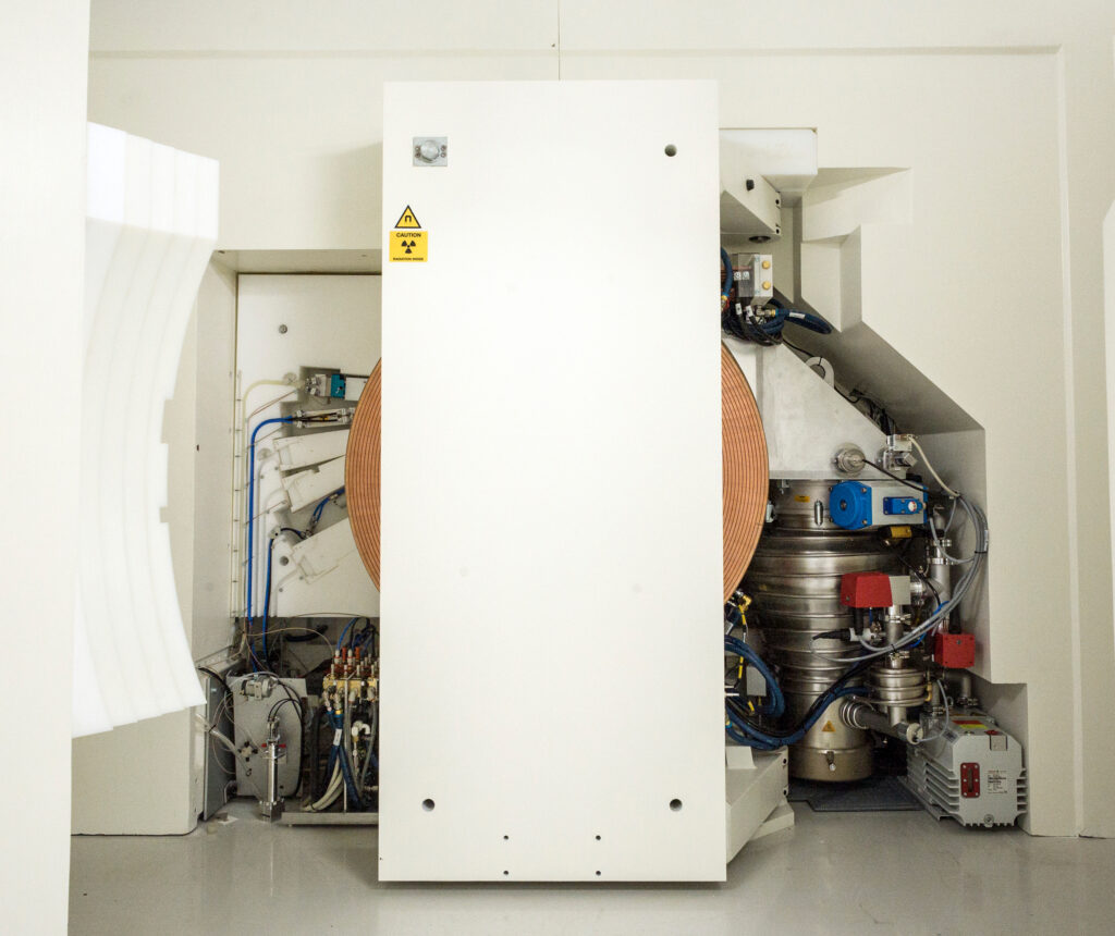 Zyklotron mit geöffnetem Strahlungsschild mit Blick auf die Targets (links), den Magneten und das Zyklotron (Mitte) sowie das Vakuumsystem (rechts) (Foto: S.F. Sämmer)